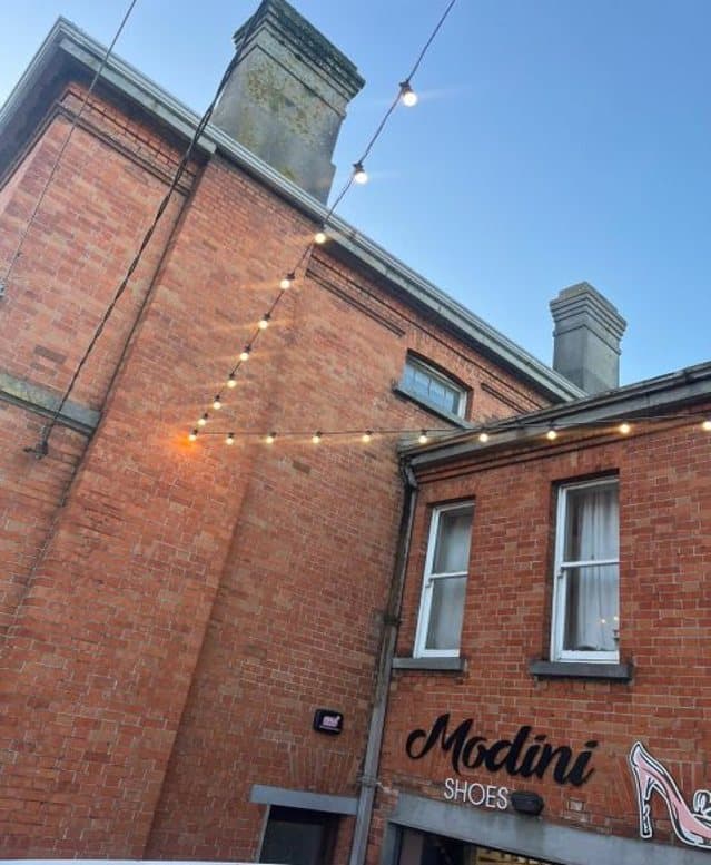 Festoon lighting anchored to a red-brick building in Newcastle West