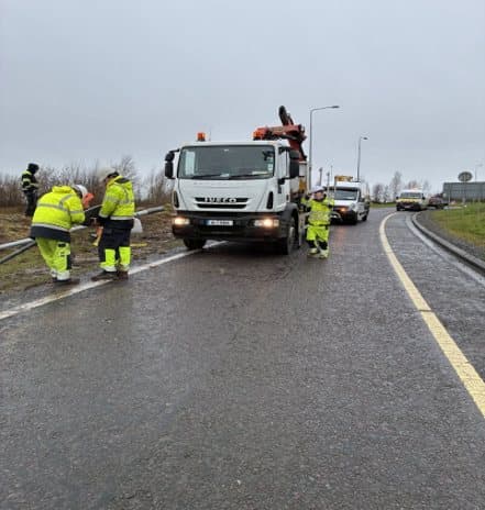 Lighting crew and crane truck working on a national road under traffic management